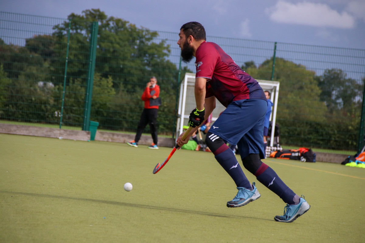 A man playing hockey on an artificial pitch