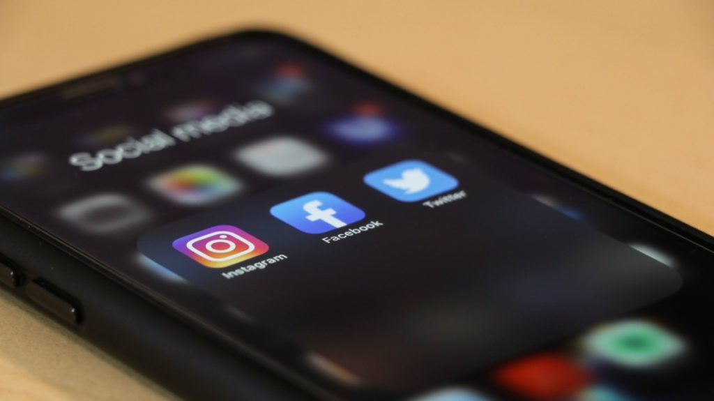 Close up of a phone screen showing social media apps