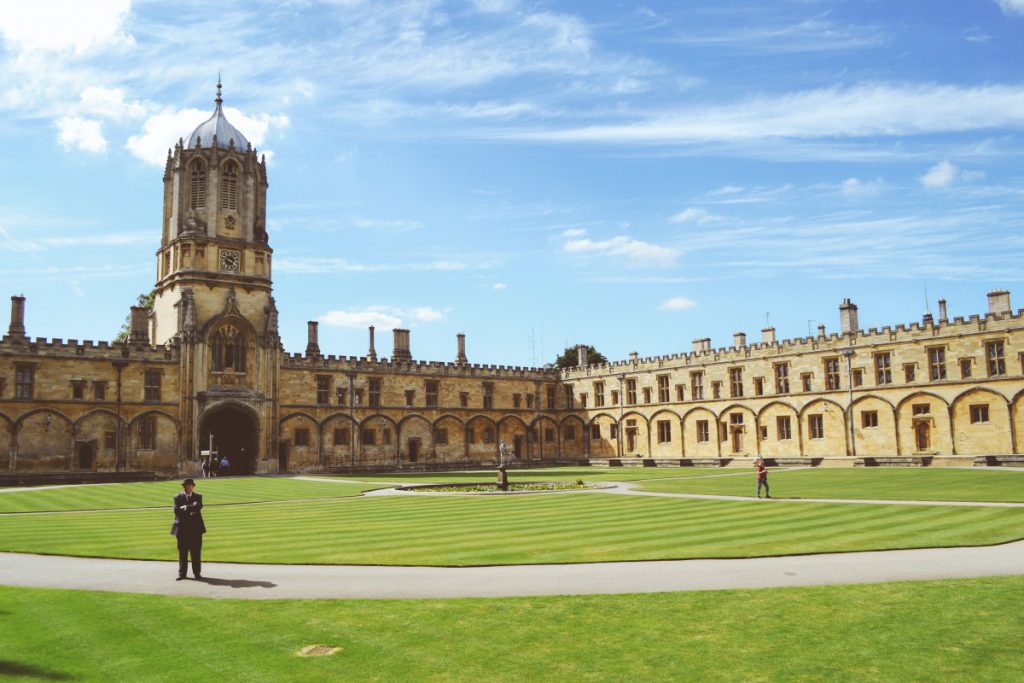 A university quadrangle with historic stone buildings and a lawn