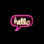 A neon sign in the shape of a speech bubble reading 'hello'