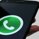 A phone showing the WhatsApp logo